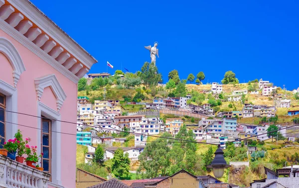 Buiten beeld van koloniale gebouwen huizen gelegen in de stad van Quito met het standbeeld van de Maagd van Panecillo op de achtergrond in prachtige zonnige dag met blauwe lucht — Stockfoto