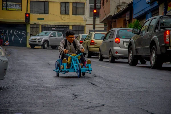 Quito, Ekwador - 21 sierpień 2018: Widok zewnątrz nastolatek w okularach jazdy trójkołowy wózek na ulicach miasta Quito — Zdjęcie stockowe