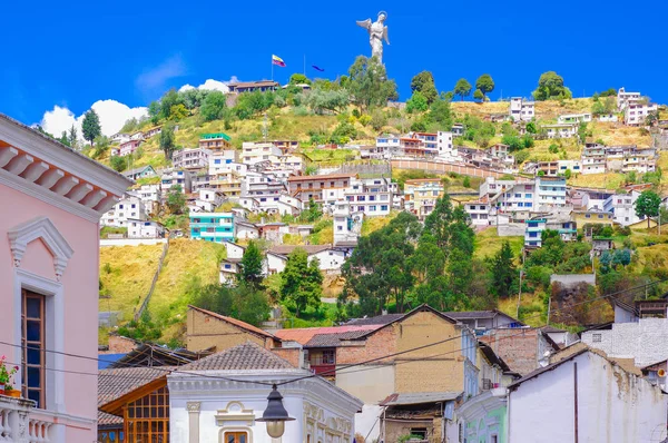 Outdoor view of colonial buildings houses located in the city of Quito with the statue of Virgin of Panecillo in the background in gorgeous sunny day with blue sky — Stock Photo, Image