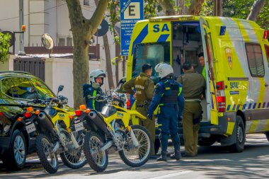 Santiago, Şili - 13 Eylül 2018: Açık görünümü grup Santiago adlı muhteşem güzel güneşli gün boyunca bitkilerle çevrili bir ekolojik Caddesi altında park etmiş ambulans yakın insan