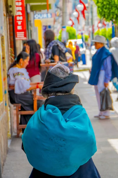 OTAVALO, ECUADOR, 06 DE NOVIEMBRE DE 2018: Vista trasera de una mujer indígena caminando en la acera de la ciudad de Otavalo — Foto de Stock