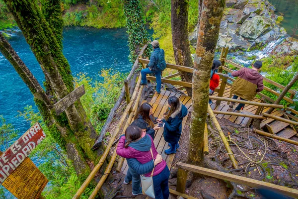 PUCON, CHILE - 23 DE SEPTIEMBRE DE 2018: Sobre la vista de turistas caminando cerca de las cascadas con algunas vallas de madera a cada lado en Pucón, Chile — Foto de Stock