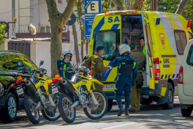 Santiago, Şili - 13 Eylül 2018: Açık görünümü grup Santiago adlı muhteşem güzel güneşli gün boyunca bitkilerle çevrili bir ekolojik Caddesi altında park etmiş ambulans yakın insan