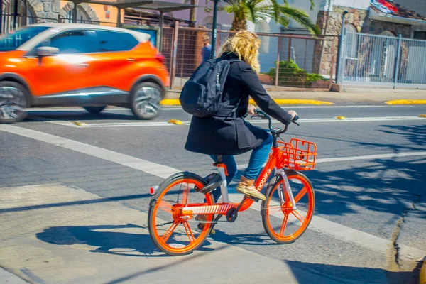 SANTIAGO, CHILE - 13 DE SEPTIEMBRE DE 2018: Mujer no identificada que pedalea su bicicleta de alquiler en la ciudad durante un hermoso día soleado en el centro de la ciudad de Santiago — Foto de Stock