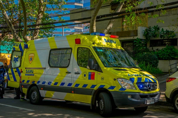 SANTIAGO, CHILE - 13 DE SEPTIEMBRE DE 2018: Vista exterior de ambulancia estacionada bajo una calle ecológica rodeada de plantas durante hermoso día soleado en Santiago —  Fotos de Stock