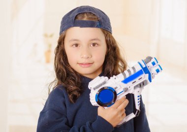 onun elinde bir silah tutan ve çocuk giyim eşyası mutlu küçük kız