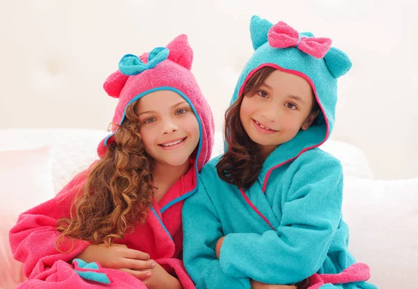 Närbild på två syster bär en bathtowel med huva — Stockfoto