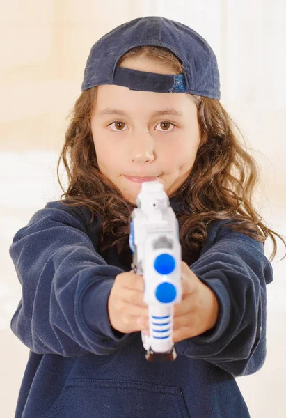 Счастливая маленькая девочка с пистолетом и в шляпе и в мужской одежде — стоковое фото