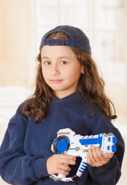 onun elinde bir silah tutan ve çocuk giyim eşyası mutlu küçük kız