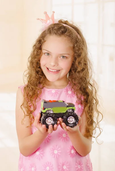 Happy little girl wearing a pink princess dress and holding a gun and wearing a hat and boy clothes — Stock Photo, Image