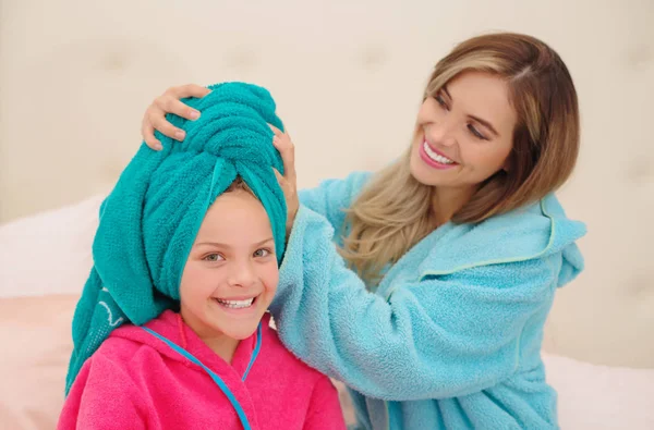 Küçük kızına mavi bir havlu ile her ikisi de bir bornoz giyiyorsun kafaya Genç Anne aplying kadar Cxlose — Stok fotoğraf