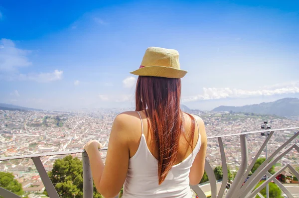 Back view of young woman wearing a panama hat and enjoying the panoramic view from el Panecillo on the historical centre of Quito — Stock Photo, Image