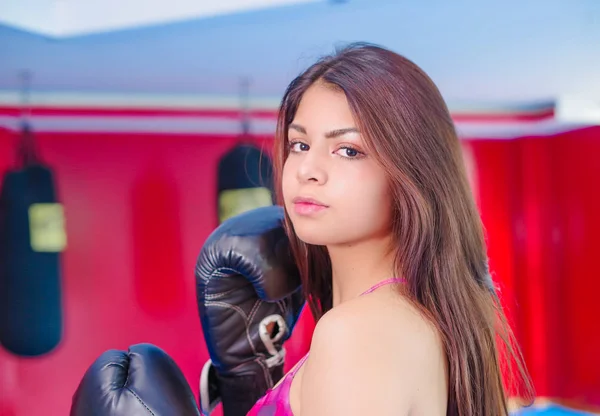Mulher linda com cabelo escuro em luvas de esportes para boxe no ginásio . — Fotografia de Stock