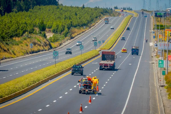 Cotopaxi, ECUADOR - 08 de septiembre de 2019: Líneas de pintura de trabajadores en carretera. Línea de carretera pintura de coches líneas blancas y marca de línea de carretera central . — Foto de Stock