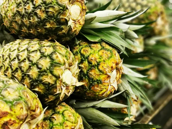 Stos owoców ananasa, który został zebrany i wyświetlania na sprzedaż na tabeli rolników na rynku — Zdjęcie stockowe