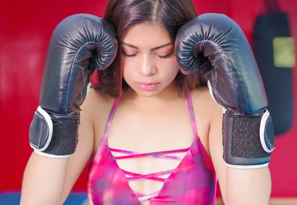 Sportos nő, Sötét haja a sportkesztyűk és lila ruhában a boksz az edzőteremben. — Stock Fotó