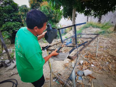 Aynı şekilde, Ekvador, 10 Ekim 2019, yan yolda tanımlanamayan kaynakçı, iki metal parçasını kaynaştırıyor.