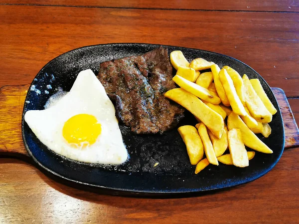 Œuf frit sain frites et steak de viande sur assiette, fond bois — Photo