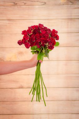 Kadınlar ellerinde bir buket Kelebek Sansasyon Gülleri çeşidi, stüdyo çekimi.