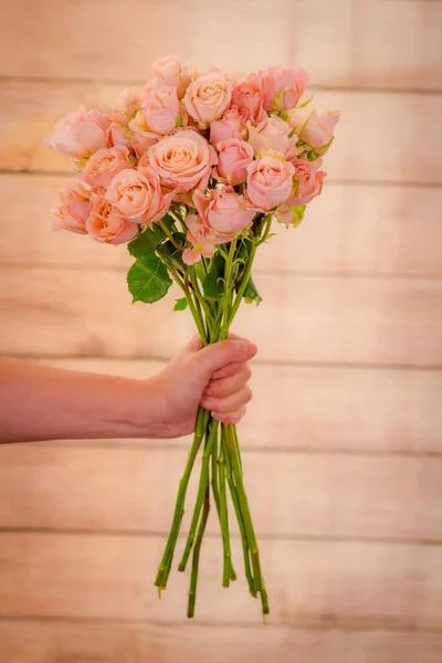 Donne mano tenendo un mazzo di Sahara Sensation varietà di rose, riprese in studio, fiori rosa — Foto Stock
