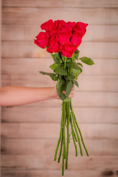 Dámské ruce drží kytici růží Hot Explorer odrůdy, studio shot. — Stock fotografie