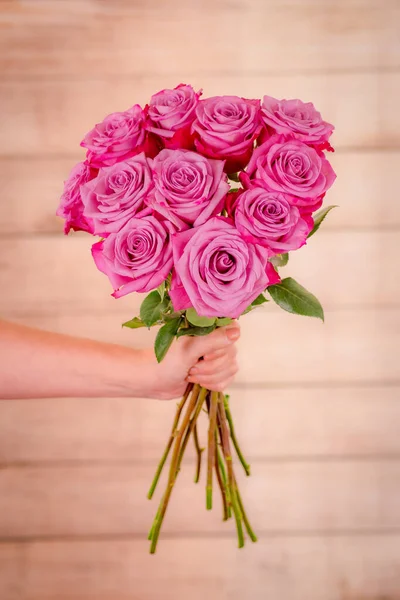 Mano de las mujeres sosteniendo un ramo de rosas Moody Blues variedad, toma de estudio . — Foto de Stock