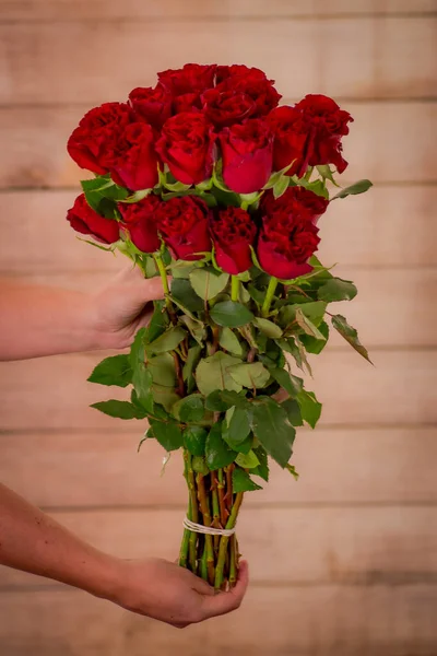 Kadınlar ellerinde bir buket Hearts Garden gülleri, stüdyo fotoğrafları, kırmızı çiçekler. — Stok fotoğraf