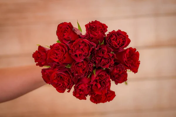 Donne mano in possesso di un mazzo di Hearts Garden varietà di rose, riprese in studio, fiori rossi — Foto Stock