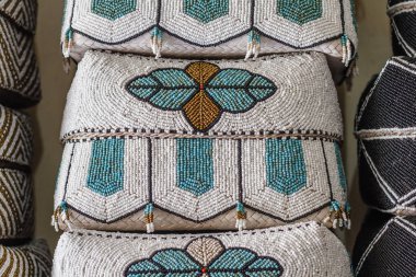 Geleneksel Balinese el yapımı boncuk ile dekore edilmiş harften denilen sepetleri sunmaktadır. Bali, Endonezya.