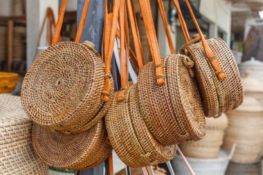 Bali dili el yapımı rattan yuvarlak omuz çantası deri işleme bir sokak dükkanında ile dokunmuş. Bali, Endonezya.