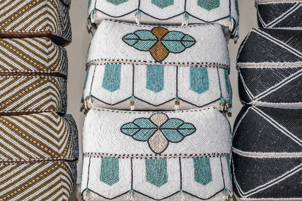 Geleneksel Balinese el yapımı boncuk ile dekore edilmiş harften denilen sepetleri sunmaktadır. Bali, Endonezya.