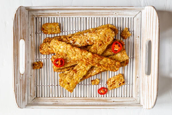 Beyaz bir tepsi içinde kızarmış Tempe dekore ahşap yüzey üzerinde serin. Üstten görünüm