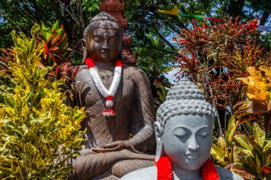 Taş için Endonezya bağımsızlık günü, Bali, Endonezya Endonezya bayrağı kırmızı ve beyaz renklerde çelenk ile ağacın altında oturan Buda heykelleri.
