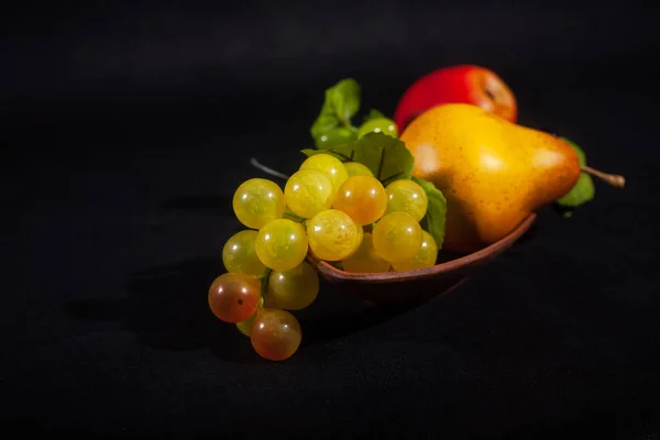 Fruit in a bowl on a black background .