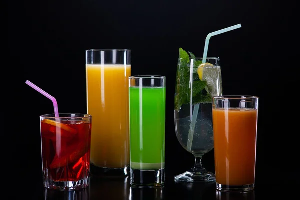 A set of cocktails of fresh fruit juices on a black background — Stock Photo, Image