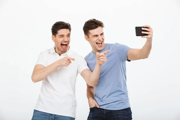 Retrato Dois Jovens Alegres Apontando Dedo Tirar Uma Selfie Isolada — Fotografia de Stock