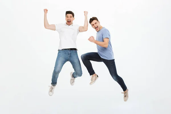 Teljes Hossza Portréja Két Izgatott Fiatalember Jumping Elszigetelt Fehér Háttér — Stock Fotó