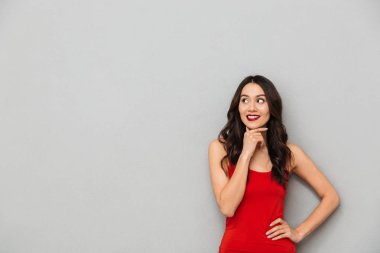 Görüntü gri duvar arka plan bir yana bakmaktan izole duran sevimli düşünme genç Asyalı kadın.