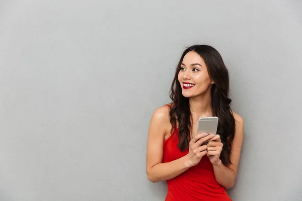 Mulher Morena Sorridente Roupas Casuais Segurando Smartphone Olhando Para Fundo — Fotografia de Stock