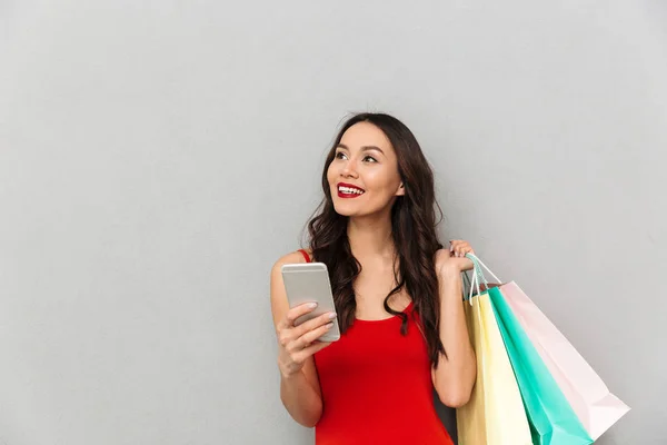 Lächelnde Brünette Frau Lässiger Kleidung Mit Paketen Die Ihr Smartphone — Stockfoto