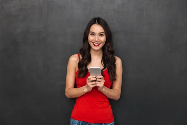 Glimlachend Brunette Vrouw Casual Kleding Bedrijf Smartphone Kijken Naar Camera — Stockfoto