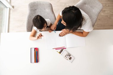 Genç kadın ve küçük çocuk ise düz masada oturan ve resim ile kalemler çizim zevk alarak Yukarıdaki görüntü