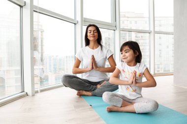 İnsanlar rahat kadın ve çocuk minderi ve tutma palms birlikte yoga kapalı oturma bağdaş pratik