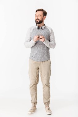 Genç adam bir yana cep telefonu arıyorum kullanarak beyaz duvar arka plan üzerinde izole gülümseyen fotoğraf.