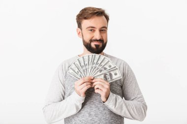 Görüntü para tutan beyaz duvar arka plan üzerinde izole mutlu genç adamın. Görünümlü kamera.