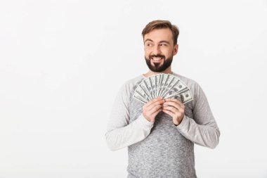 Görüntü para tutan beyaz duvar arka plan üzerinde izole mutlu genç adamın. Bir kenara arıyorsunuz.