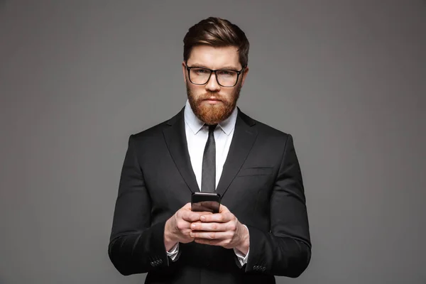 Portret Pewnie Młody Biznesmen Ubranego Garnitur Trzymając Telefon Komórkowy Białym — Zdjęcie stockowe