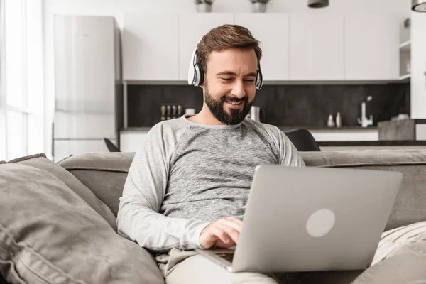 Retrato Joven Sonriente Con Auriculares Trabajando Ordenador Portátil Mientras Está — Foto de Stock