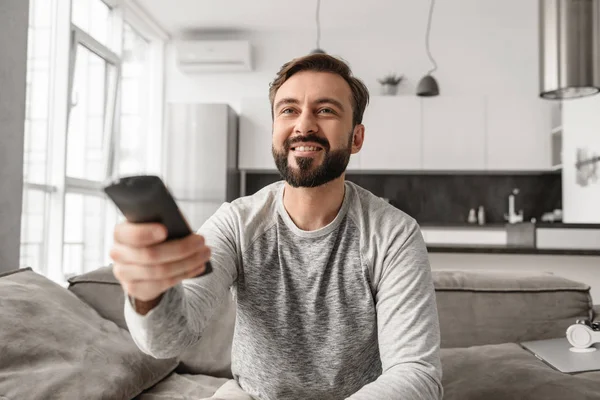 Ritratto Giovane Felice Che Tiene Telecomando Della Seduto Divano Casa — Foto Stock