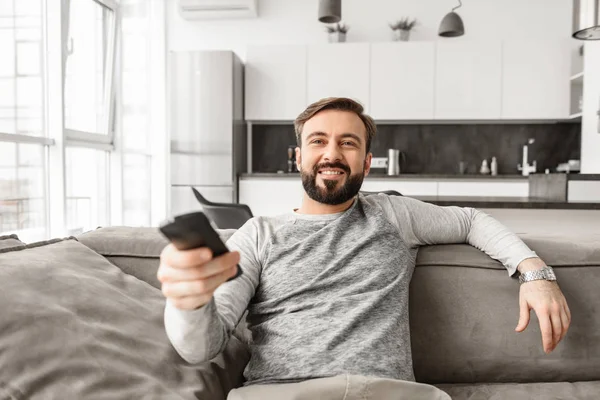 Ritratto Giovane Felice Che Tiene Telecomando Della Seduto Divano Casa — Foto Stock